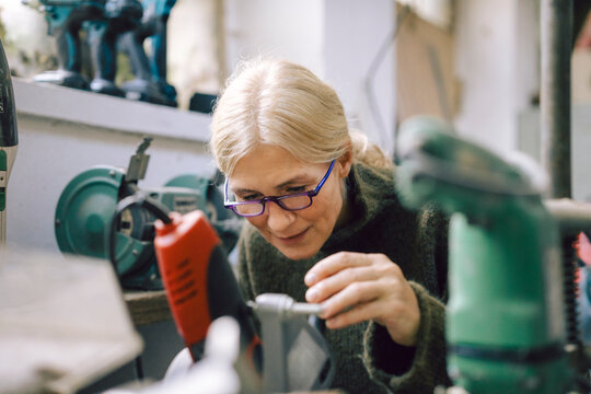 Small business owner working with tools in a workshop