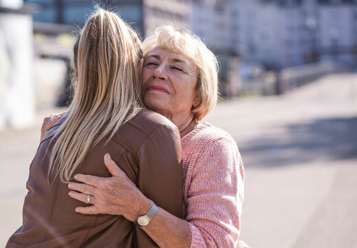Grandma hugging and smiling outdoors showing affection and care