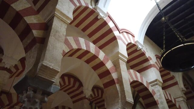 Symmetrical arches corridor in Cordoba mosque geometric perspective interior Spain
