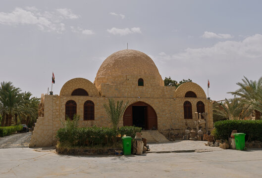Sunlit domed building with traditional stonework in an Egyptian oasis