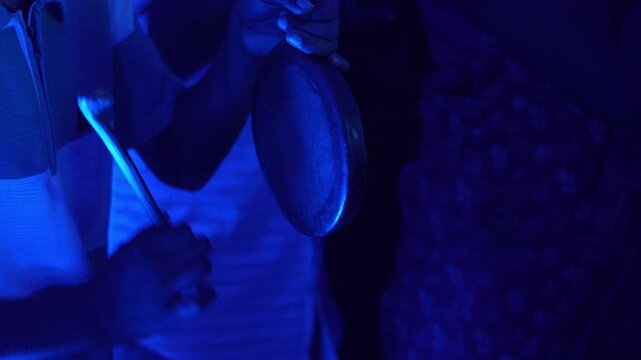 Close up of a small hand bell being played in dark environment, creating a mysterious cinematic