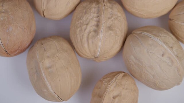 Detailed image showcasing rough shells and warm earthy hues. Picture of raw walnuts featuring textured shells and repeating rustic aesthetic for various projects