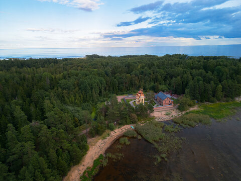 Aerial view of Russian Orthodox Skete with red brick architecture, Lake Ladoga shore, Konevets Island, Leningrad Region.