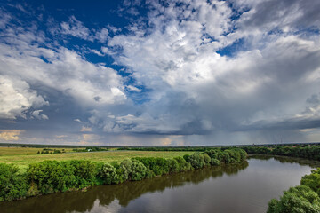 Fototapeta premium Serene river winds through lush green landscape