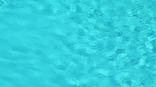 waves of water on surface of swimming pool with blue water, close-up, slow motion
