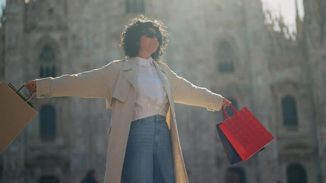 Joyful Woman with Shopping Bags Rotating at Milan Duomo Sunrise