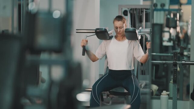 Athletic woman performing squats on a hack squat machine