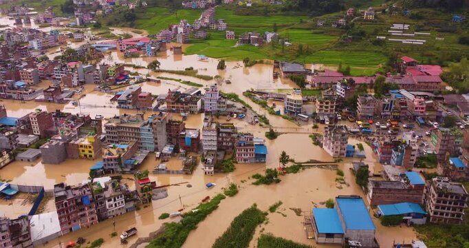 Aerial drone shot of trucks and vehicles submerged in deep floodwaters along the blocked Araniko Highway in Banepa Nepal during a severe monsoon disaster.