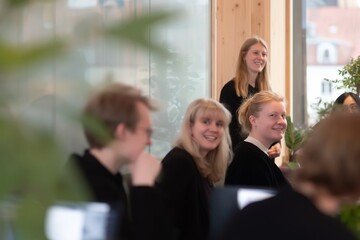 Obraz premium Coworkers laughing together in office showing teamwork collaboration and positive modern workplace environment
