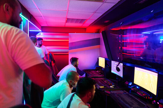 Esports Team Competing in Neon-Lit Gaming Room With Computers and Intense Focused Players