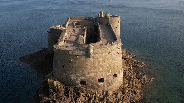 Aerial view of the imposing Chateau du Taureau, a stone fortress rising from the dark, swirling sea, its weathered walls telling tales of centuries past, Plouezoc'h, Bretagne, France.