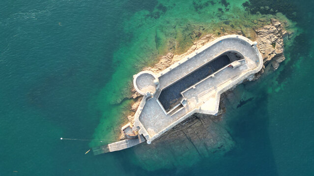 Aerial view of the Chateau du Taureau, a stone fortress island standing resolute amidst the turquoise waters of the bay, Plouezoc'h, Bretagne, France.