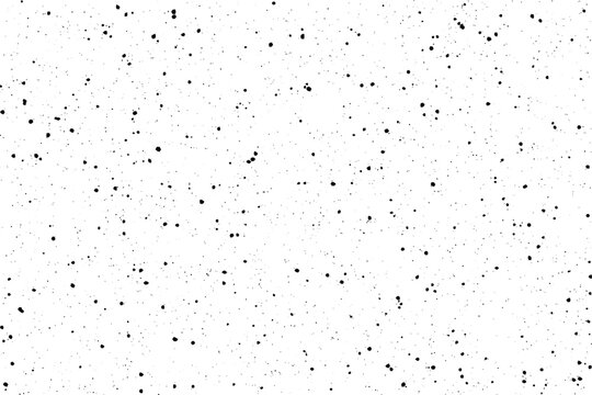 Scattered tiny black dots create a subtle textured pattern on a bright white surface
