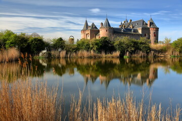 Obraz premium Reflections of Muiderslot Castle, a medieval castle located in Muiden, Amsterdam, Netherlands, viewed from the countryside around the village of Muiden