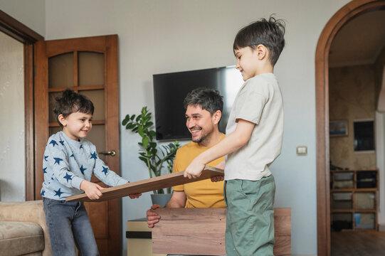 Father and children assembling furniture together at home