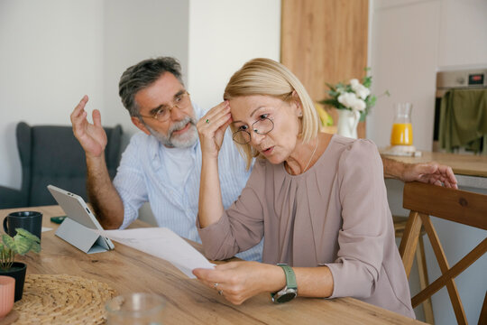 Couple discussing financial problems with bills at home