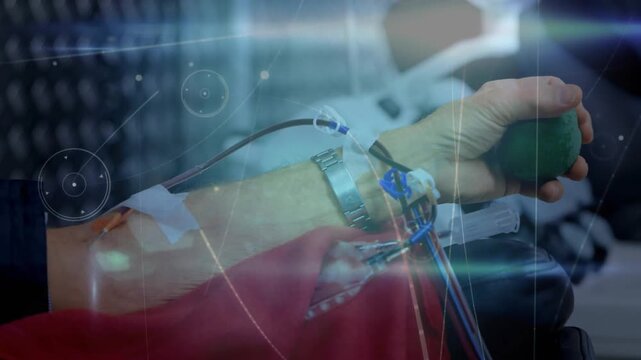 Vertical video: Donor hand squeezing green ball, blood filling tubing after needle to collect blood