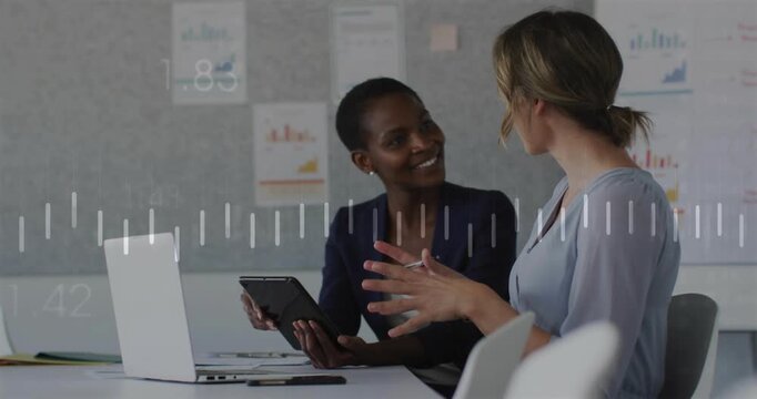 Right woman leading, animating waveform while left woman tapping tablet, reviewing business charts