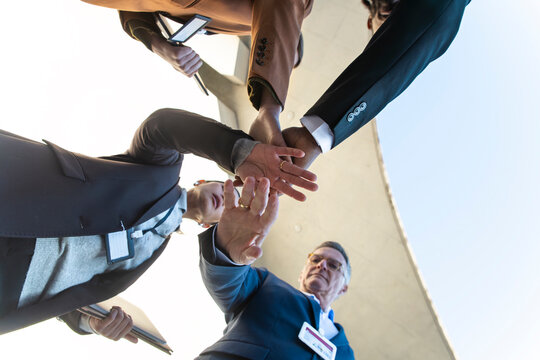 Business team stacking hands in convention center