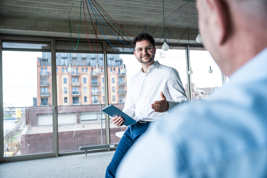 Business team discussing project with tablet at modern office