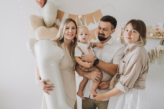 Parents hugging baby during first birthday family celebration