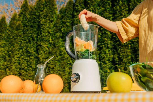 Preparing fresh fruit and vegetable smoothie outdoors in spring