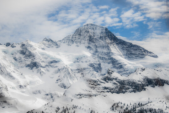 View of snow-capped mountain peaks pierce the sky, their icy faces reflecting the soft light, contrasting against the blue sky, Murren, Switzerland.