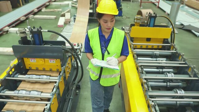 Female worker inspect rust proof coated corrugated metal sheets ensuring strength aesthetics before shipment distributors within the industrial metal sheet manufacturing plant.