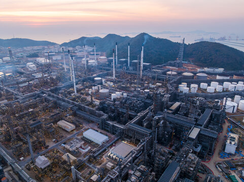 Industrial Petroleum Refinery Infrastructure Complex Operating At Sunrise Near The Coast