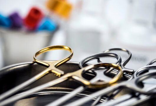 Syringes and scissors of suture in a tray metal, conceptual image