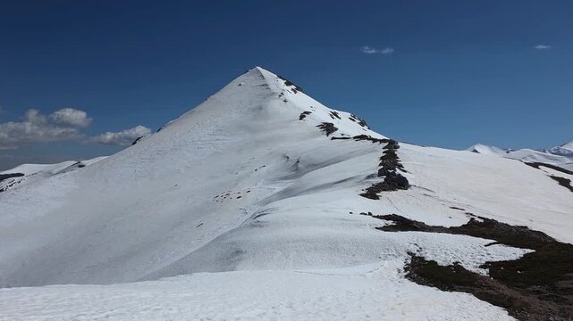 Pyramidal Peak of Monte Puzzillo Covered in Snow, Spring apennines landscape in Abruzzo Apennines, Central Italy, Sharp Mountain Ridge under Clear Blue Sky