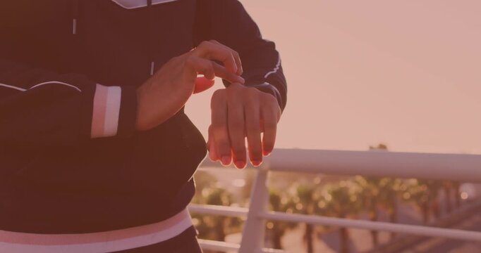 Mid section of a man using smartwatch on the city bridge