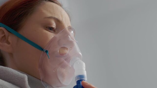 A woman uses a nebulizer at home to treat pneumonia. The treatment involves saline and helps manage lung issues caused by polluted air and allergies.