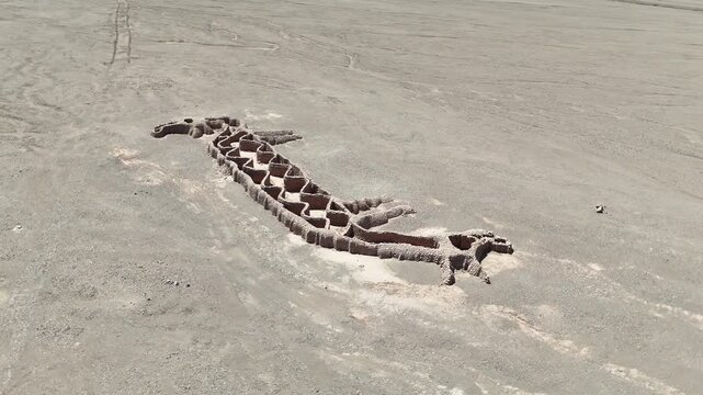 Cinematic orbit circling the "Two-Headed Llama" (La Llama de Dos Cabezas) geoglyph in the Vallecito area near San Pedro de Atacama, Chile