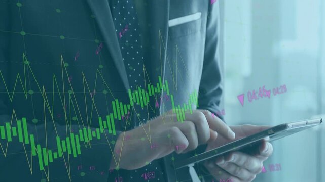 Businessman uses tablet with finance graphs in video.