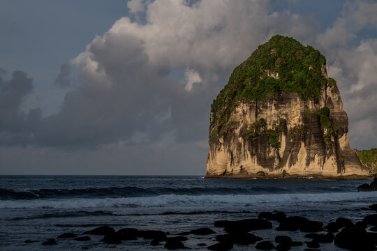 Pangasan Beach is located in Pacitan Regency, East Java, Indonesia, with high limestone cliffs towering firmly on both sides of the beach.