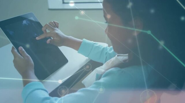 Female child tapping tablet by window and causing network overlay growth, aiding education