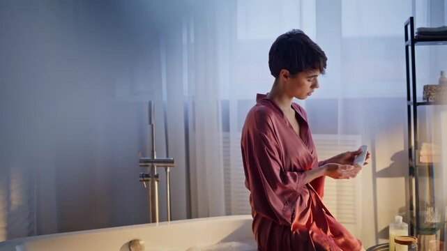 Polished woman taking cream smoothing sunny morning bath. Lady applying lotion