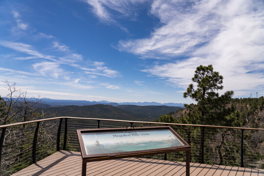 An interpretive sign on a viewing deck overlooks the vast forested expanse of the Mogollon Rim in central Arizona, USA
