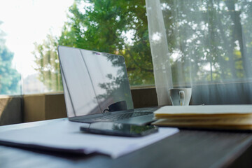 Fototapeta premium Flat lay of professional desk with business charts on laptop screen, smartphone and notepad.