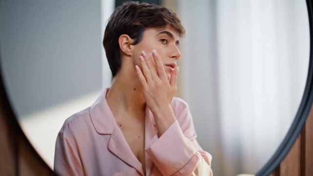 Pyjama girl holding cream jar massaging bathroom closeup. Woman pampering skin