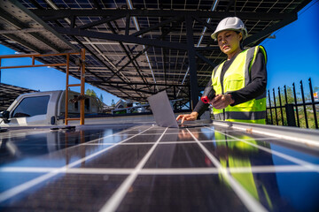 Fototapeta premium Engineer in safety vest and helmet pointing towards a solar powered carport, illustrating eco-friendly innovation in parking infrastructure. Solar panels provide shade and sustainable energy.