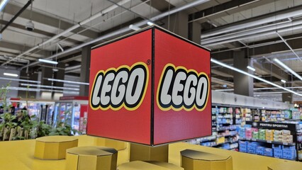 Naklejka premium Close-up of a large red cube featuring the yellow and white LEGO logo in a store, on April 10, 2026 in Bucharest, Romania.