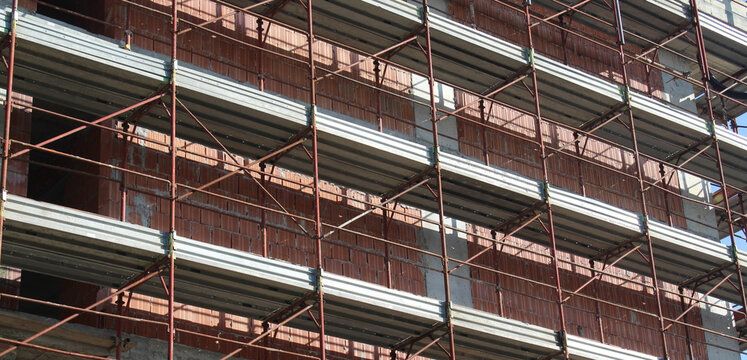 Lavori in corso nel cantiere edile in primavera - gru e ponteggio
