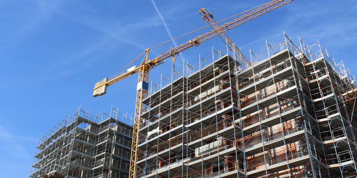 Lavori in corso nel cantiere edile in primavera - gru e ponteggio