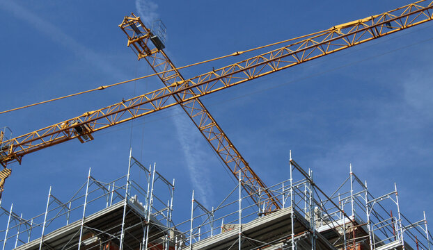 Lavori in corso nel cantiere edile in primavera - gru e ponteggio