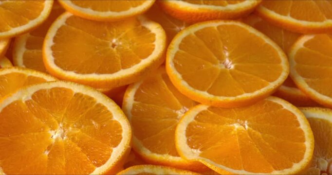 Unpeeled orange slices. Selective focus, table spin.