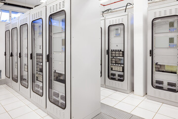 A clean and organized electric room features rows of specialized control panels and protection...