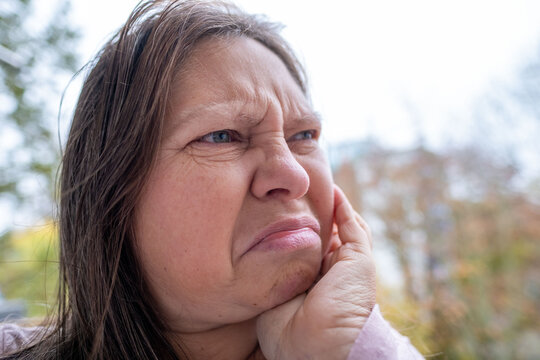 Furious woman staring aggressively, Middle-aged woman making disgusted face outdoors, Facial expression of discomfort, surprise, or awkward social situation, negative social situation