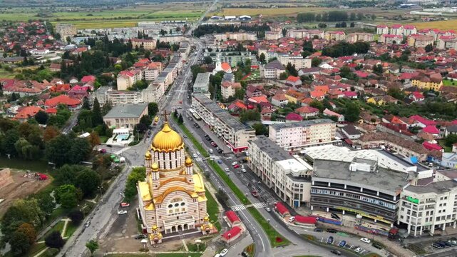 Drone footage flying over city with golden domed cathedral and urban sprawl in distance.